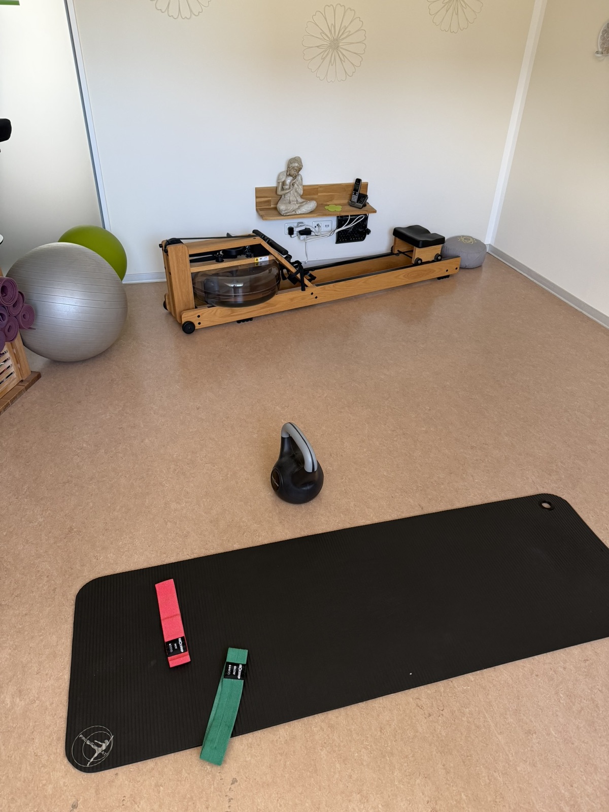 Trainingsmatte, Widerstandsbänder, Kettlebell und Rudergerät im Indoor-Trainingsraum